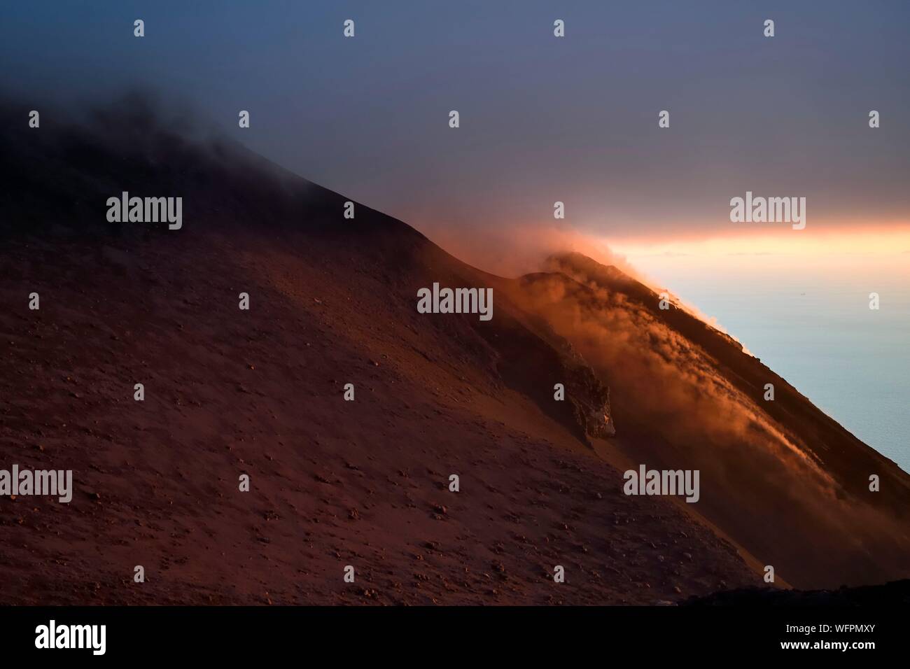 L'Italia, Sicilia e Isole Eolie, classificato come patrimonio mondiale dall UNESCO, Stromboli, fumarole di una eruzione e la caduta delle bombe di lava sulle pendici del vulcano attivo al tramonto Foto Stock