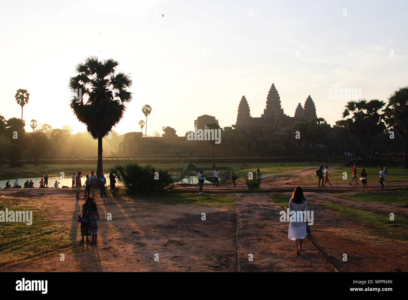 Sunrise in Angkor Wat con tourist in cammino verso il tempio nella prima luce del mattino Foto Stock