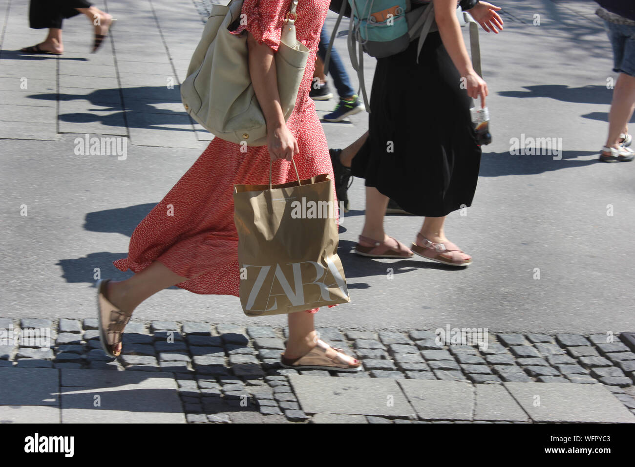 Donna che tiene il sacchetto di carta. Affrettarsi con la borsa ZARA  attraverso l'area pedonale, shopping economico nella catena di negozi Foto  stock - Alamy