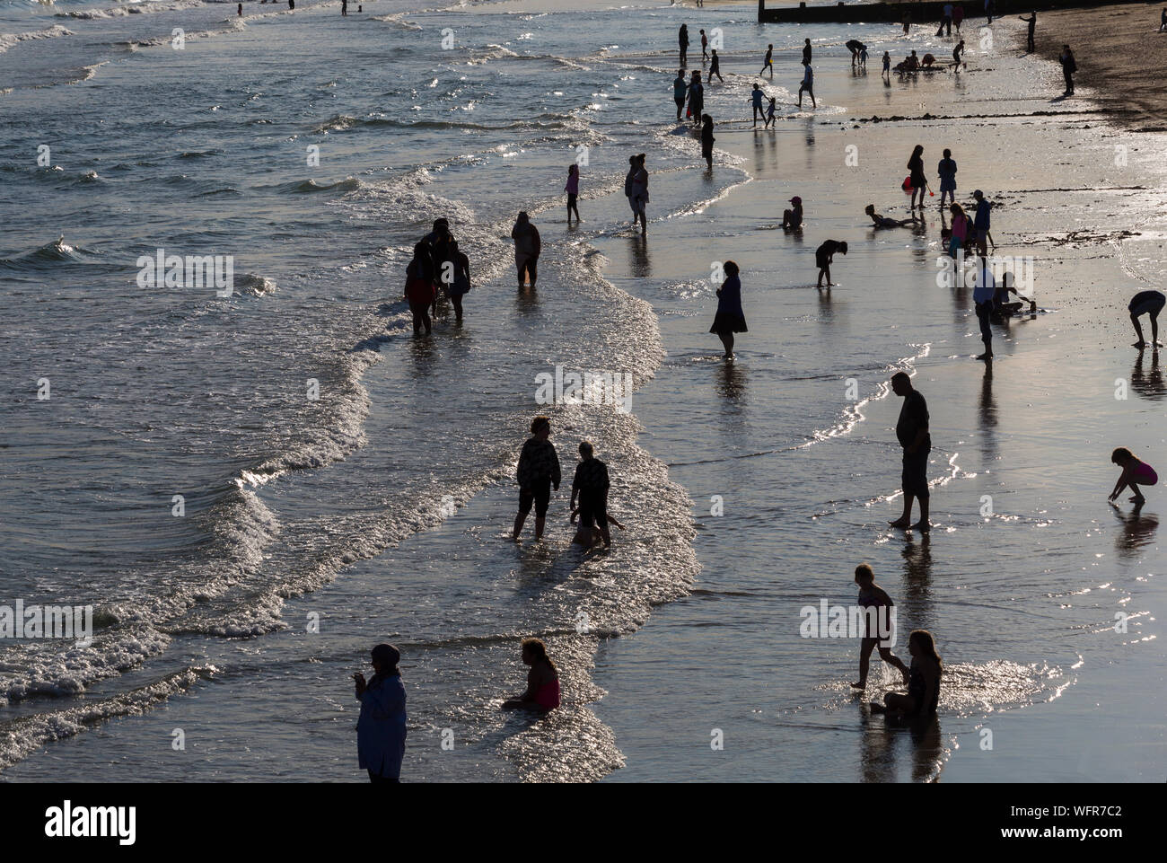 Bournemouth Dorset UK. Il 31 agosto 2019. Regno Unito: meteo visitatori apprezzano i resti del giorno a Bournemouth Beach stagliano figure come il sole scende dopo un giorno misti di meteo - piovoso e umido pomeriggio presto, trasformando in una gloriosa caldo e soleggiato nel pomeriggio e la sera come la folla gregge al mare a Bournemouth Beach per guardare il Bournemouth air festival. Credito: Carolyn Jenkins/Alamy Live News Foto Stock