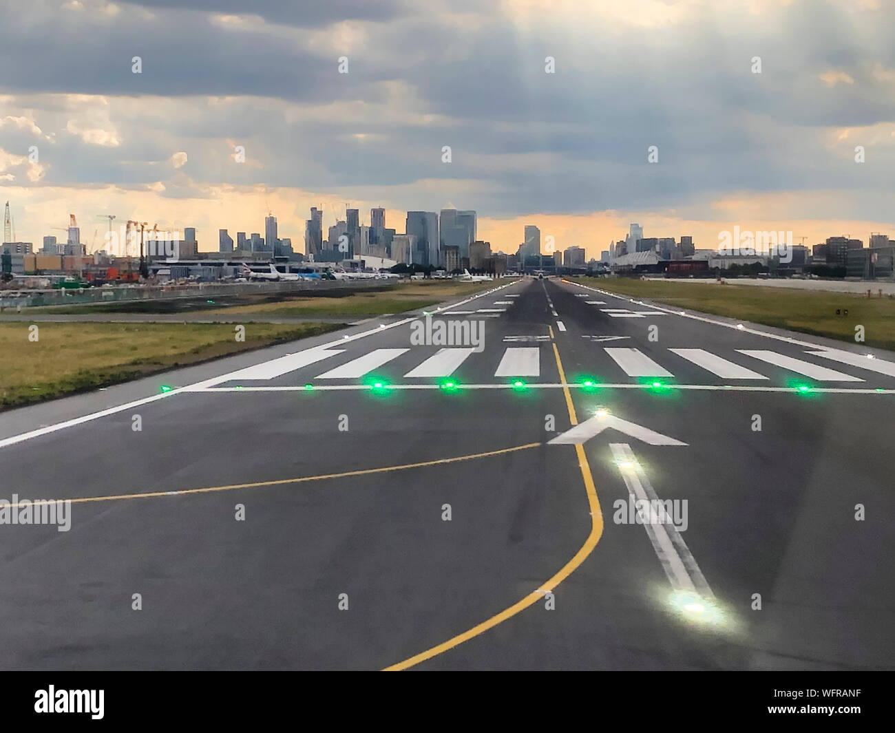London, Regno Unito - 12 Luglio 2019: il quartiere finanziario di Londra di Canary Wharf è visibile a destra nel prolungamento della pista 27 del London City Airport (LCY). Foto Stock