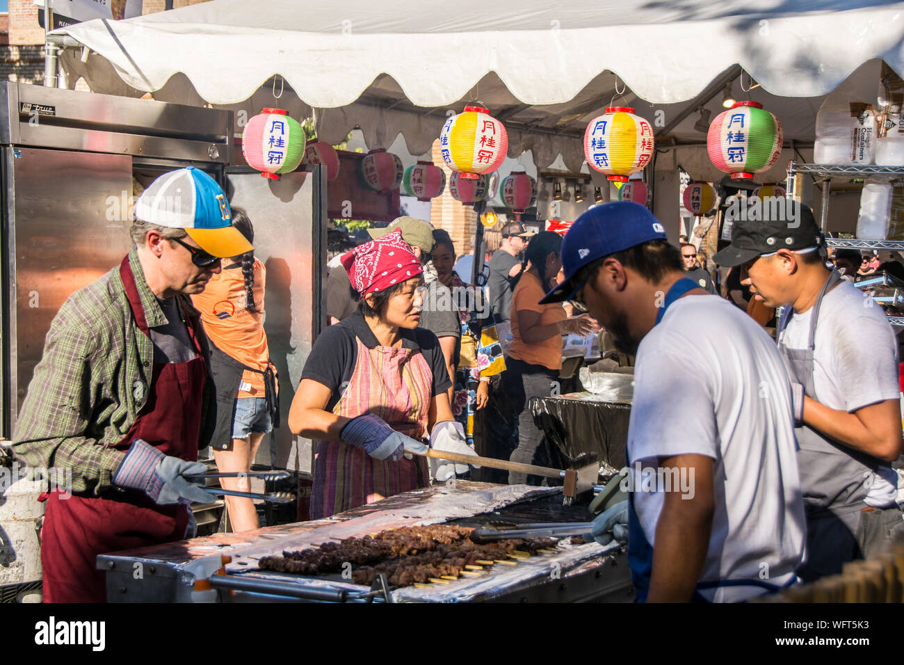 Un gruppo di individui la cottura/cottura alla griglia di cibi durante la Orange International Food Fair, una tradizione annuale sponsorizzata dalla città di Orange. Foto Stock