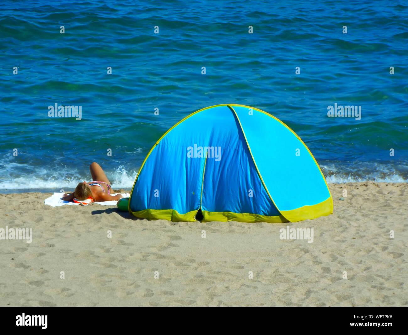 La donna a prendere il sole in tenda in riva al mare Foto stock - Alamy