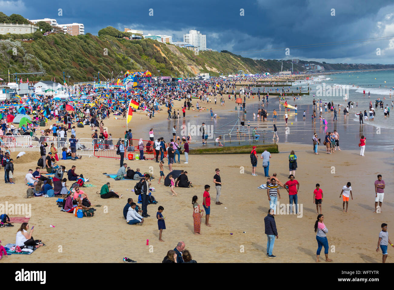 Bournemouth Dorset UK. Il 31 agosto 2019. Regno Unito: meteo folla gregge a Bournemouth Beach, a guardare il Bournemouth air festival, dopo una giornata mista di meteo - piovoso e umido pomeriggio presto, trasformando in una gloriosa caldo e soleggiato nel pomeriggio e la sera. Illuminazione drammatica e cielo tempestoso. Credito: Carolyn Jenkins/Alamy Live News Foto Stock