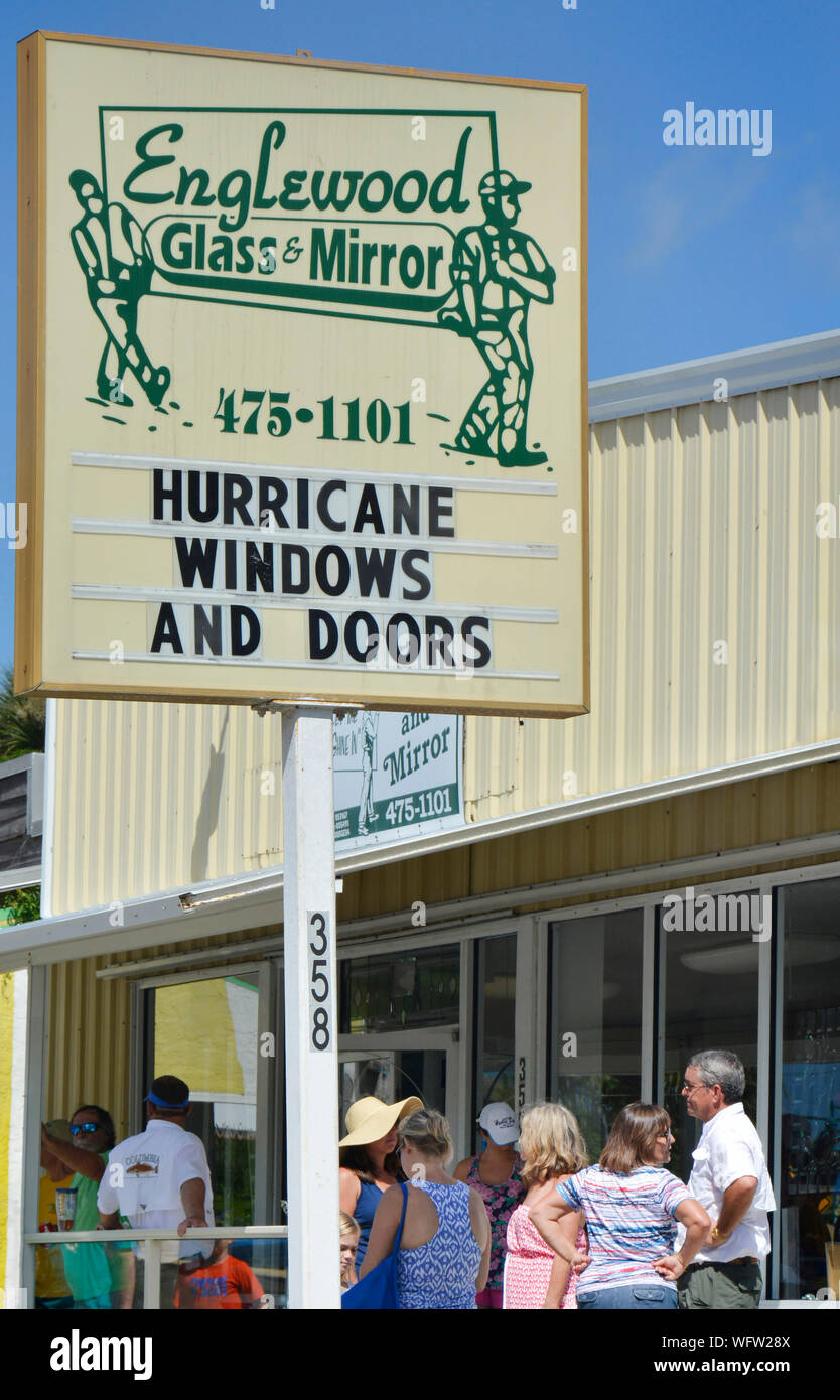 La gente cerca di lottare contro le portiche a Englewood, FL, mentre un uragano si avvicina, accodandosi al negozio di vetro & specchio per l'uragano Windows & Doors Foto Stock