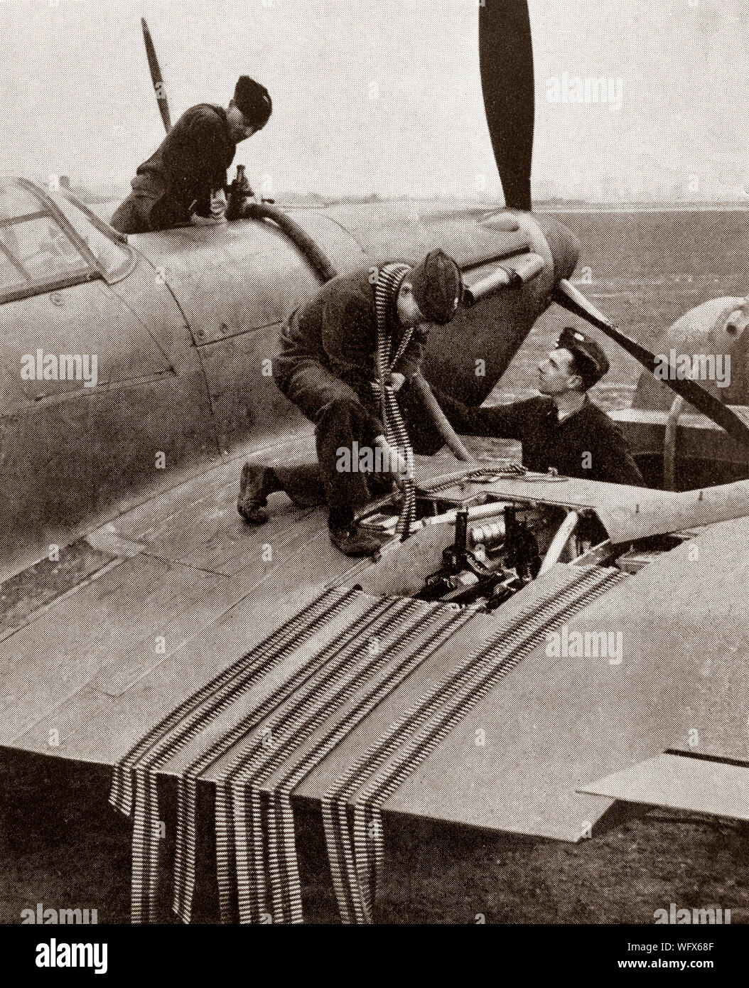 Groundcrew caricamento di munizioni in un'ala di un Hawker Hurricane, il britannico a singola sede degli aerei da caccia con la RAF. Essa è stata oscurata nella coscienza pubblica mediante il Supermarine Spitfire il ruolo durante la Battaglia di Gran Bretagna nel 1940, ma l'uragano ha inflitto il 60 percento delle perdite subite dalla Luftwaffe in impegno, e combattuto in tutti i maggiori teatri della Seconda Guerra Mondiale. Foto Stock