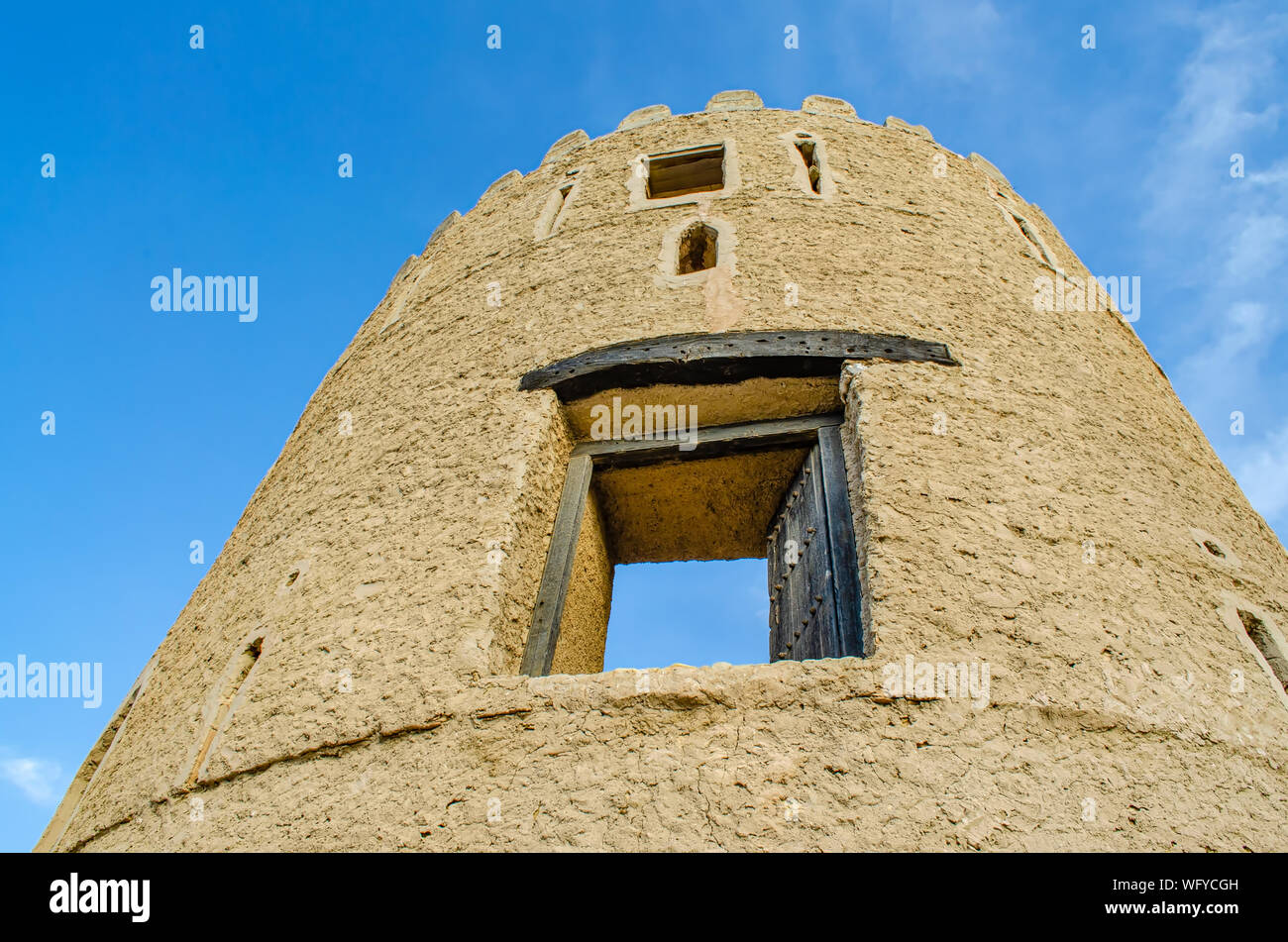 Antica torre di avvistamento di una vecchia fortezza che si elevano fino al cielo - colpo da sotto. Da Muscat Oman. Foto Stock