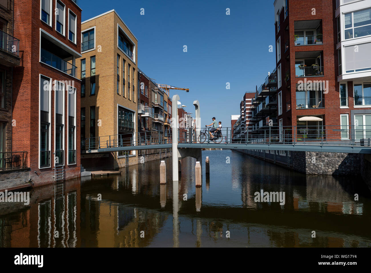 Architettura contemporanea nella nuova costruzione quartiere Houthaven in fase di costruzione con una gru in background Foto Stock