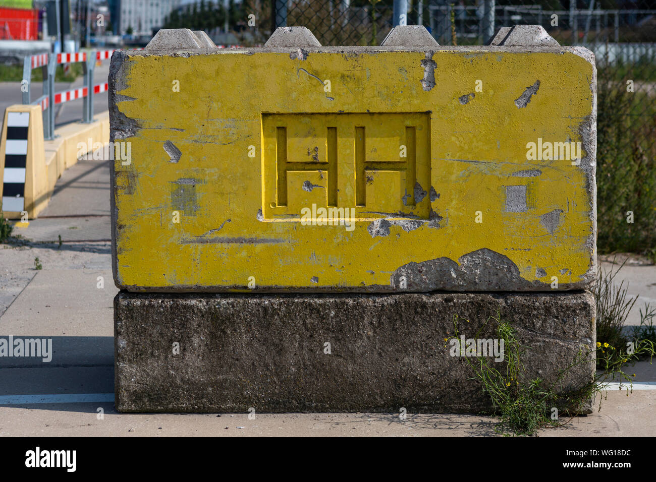 Blocco di cemento dipinto di giallo blocca la strada in costruzione Houthaven quartiere con le iniziali di HH Foto Stock