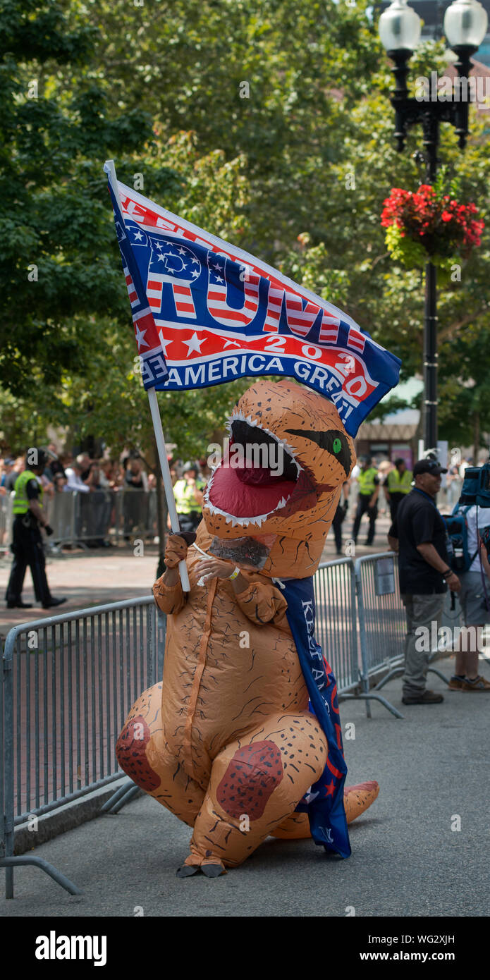 Boston, MA, Stati Uniti d'America. Il 31 agosto 2019. Centinaia di marzo in rettilineo Pride Parade attraverso Boston, MA. I dimostranti, i sostenitori di U.S. Presidente Donald Trump, furono sopraffatti da anti-Trump e diritti dei gay sostenitori. Il rettilineo di orgoglio il mese di marzo è stato organizzato dalla neonata "Super Happy Fun America", che ha organizzato la manifestazione di Boston come una risposta al Gay Pride parate che sono state detenute in la maggior parte dei principali U.S, città. La foto mostra un uomo vestito come un dinosauro che trasportano un Trump 2020 su Boylston Street all'inizio della sfilata. Mandrino di credito Nacke / Alamy Live News Foto Stock