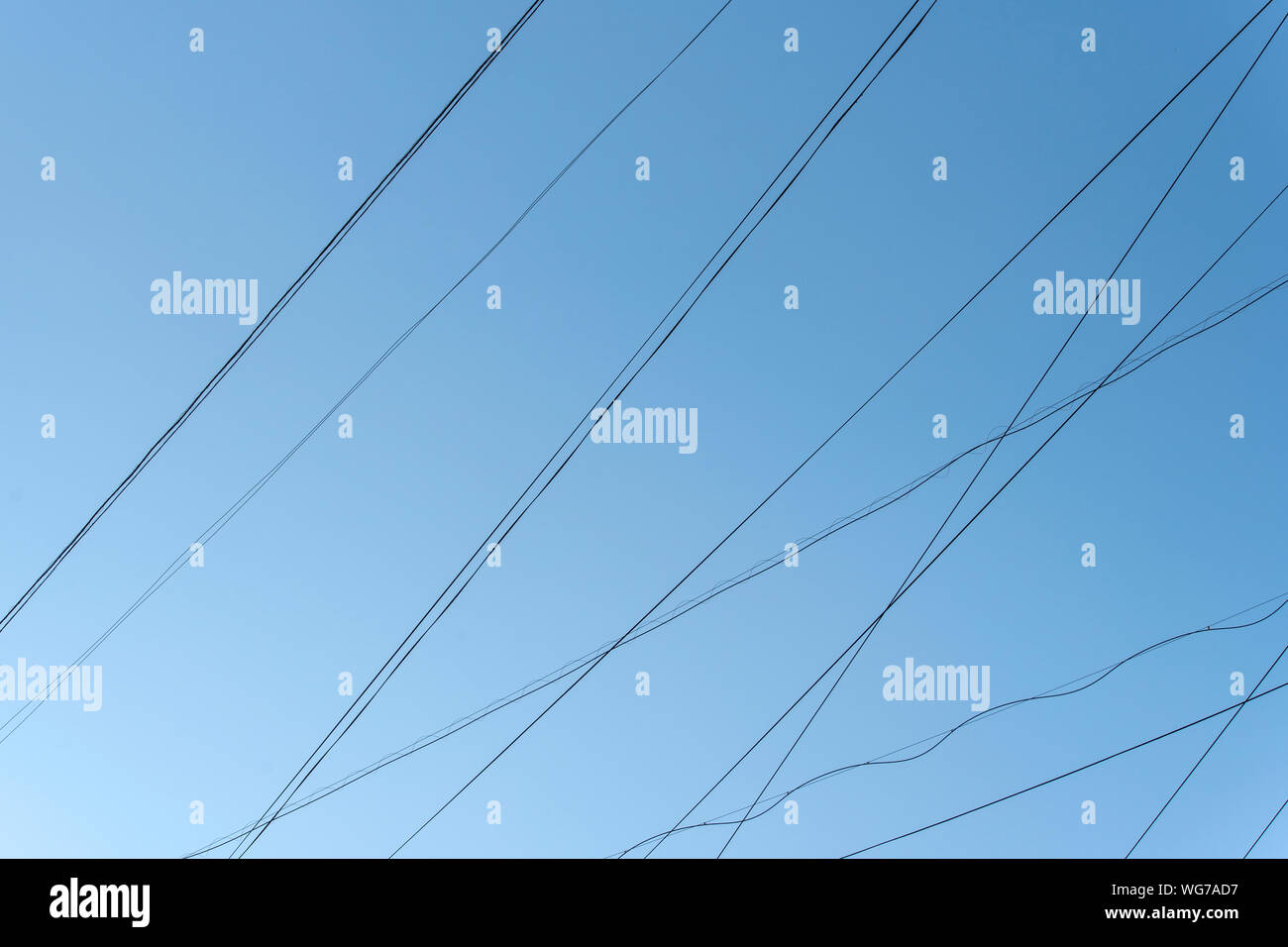 Linee astratte di cavi elettrici i fili con il cielo azzurro in città Foto Stock