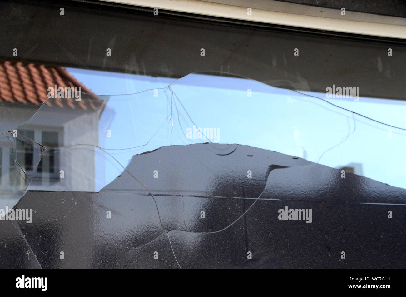 Frattura termica nella vetrina di un negozio a causa di copertura nera con foglio di plastica che ha causato il surriscaldamento del bicchiere. Atti di vandalismo avrebbe dimostrato impatto Foto Stock