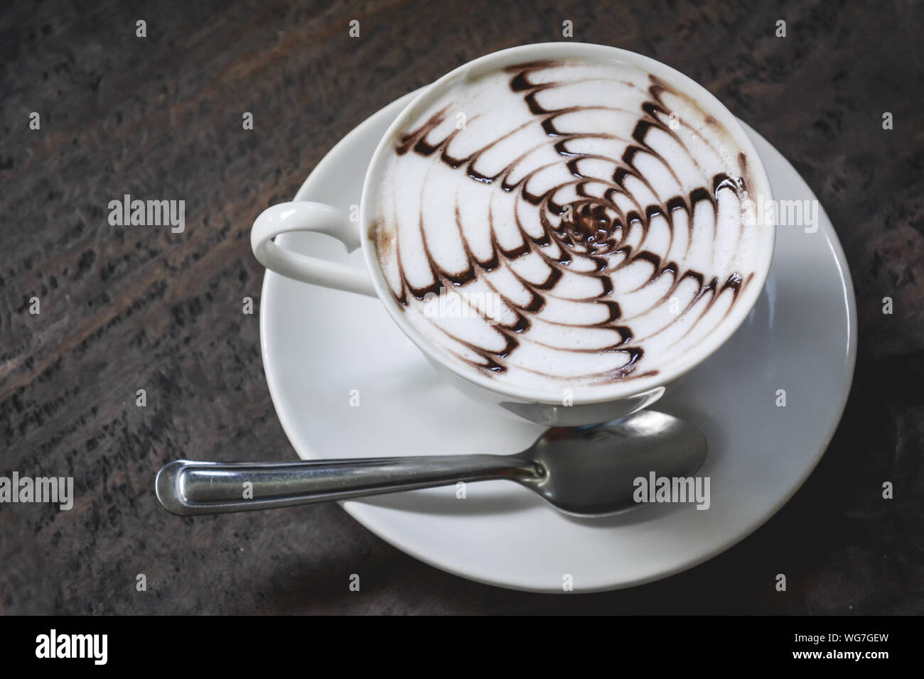 Angolo di Alta Vista della tazza di caffè nel piattino sul tavolo Foto Stock
