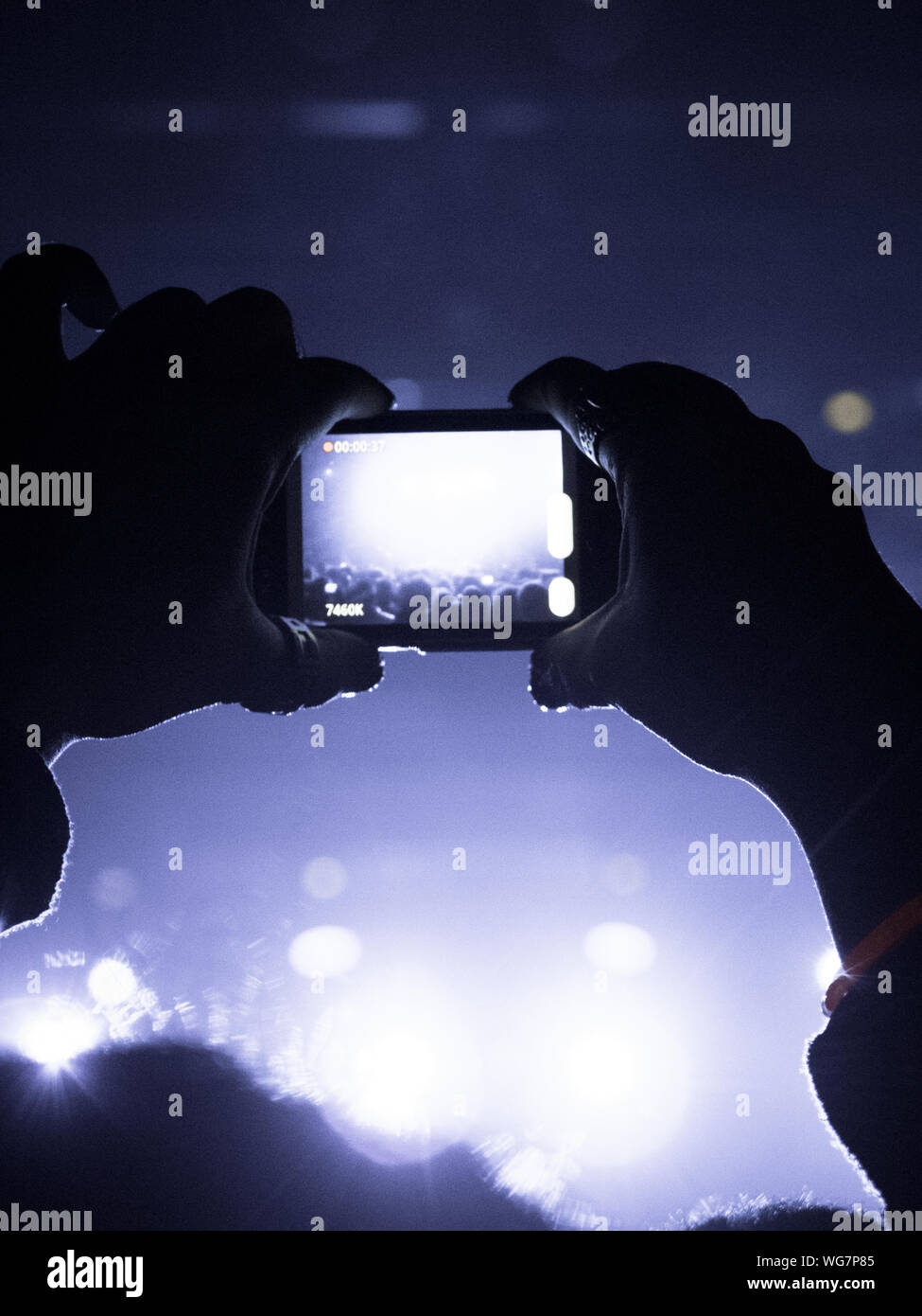 Concerto folla battendo le mani di fronte a bright stage Foto Stock