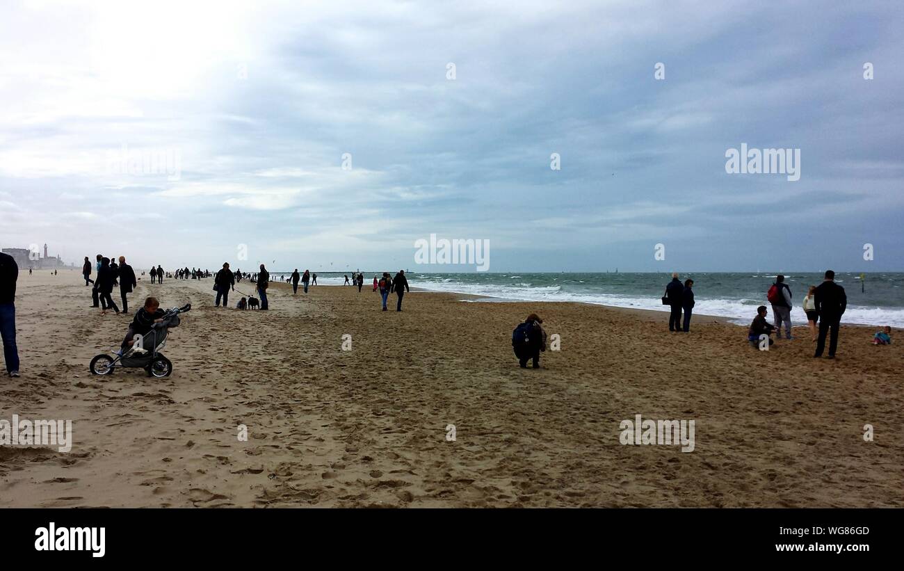 Un folto gruppo di persone sulla spiaggia di sabbia di temperatura freddo Foto Stock