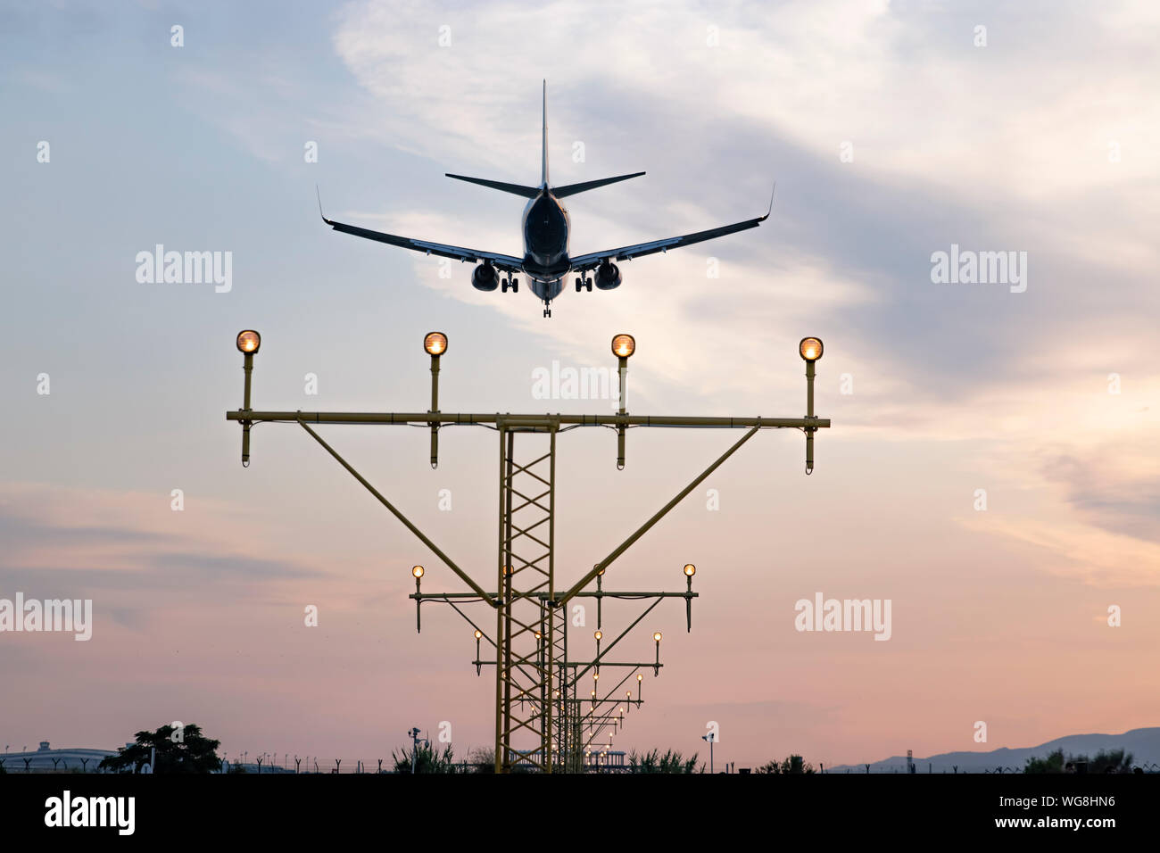 Aeromobile durante la procedura di avvicinamento al tramonto sorvolo della pista di luci. Approccio di precisione ILS-guidato lo sbarco. Foto Stock