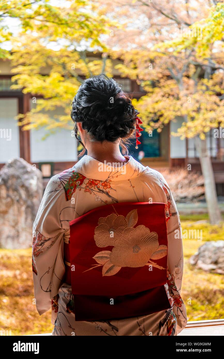 Donna Giapponese vestito con un kimono, guardando nel cortile di O-shoin, Kennin-ji, Higashiyama, Kyoto, Giappone Foto Stock
