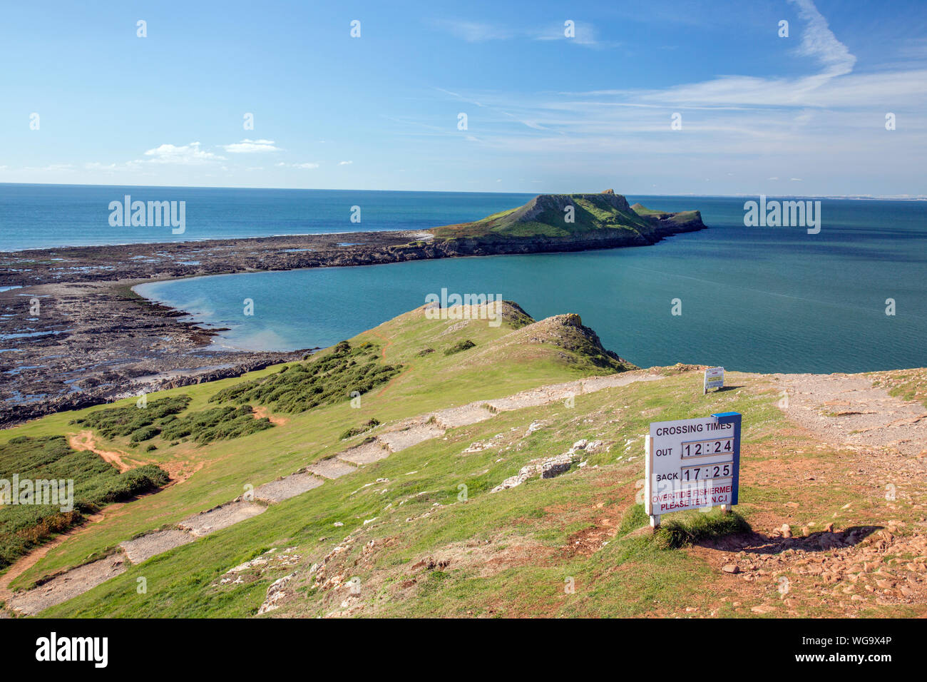 Segnale di avvertimento dando orari delle maree quando è possibile attraversare a Worms testa sulla Penisola di Gower, South Wales, Regno Unito Foto Stock