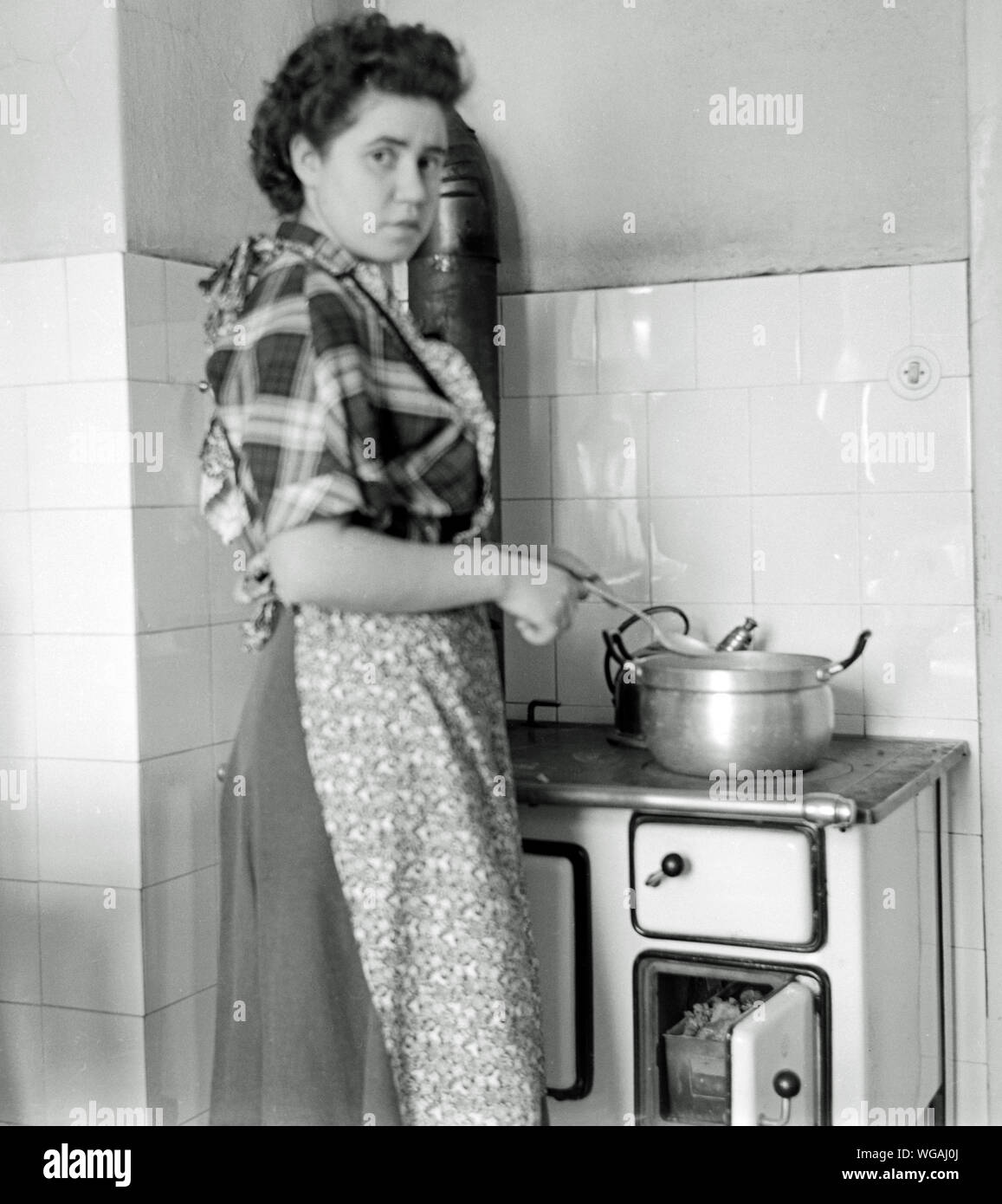 Europa, Deutschland, Amburgo, Hausfrau am Kohleherd beim Kochen, 1950er Jahre . / Europa, Germania, Amburgo, casalinga vicino alla stufa a carbone, cottura , 1950th . Foto Stock