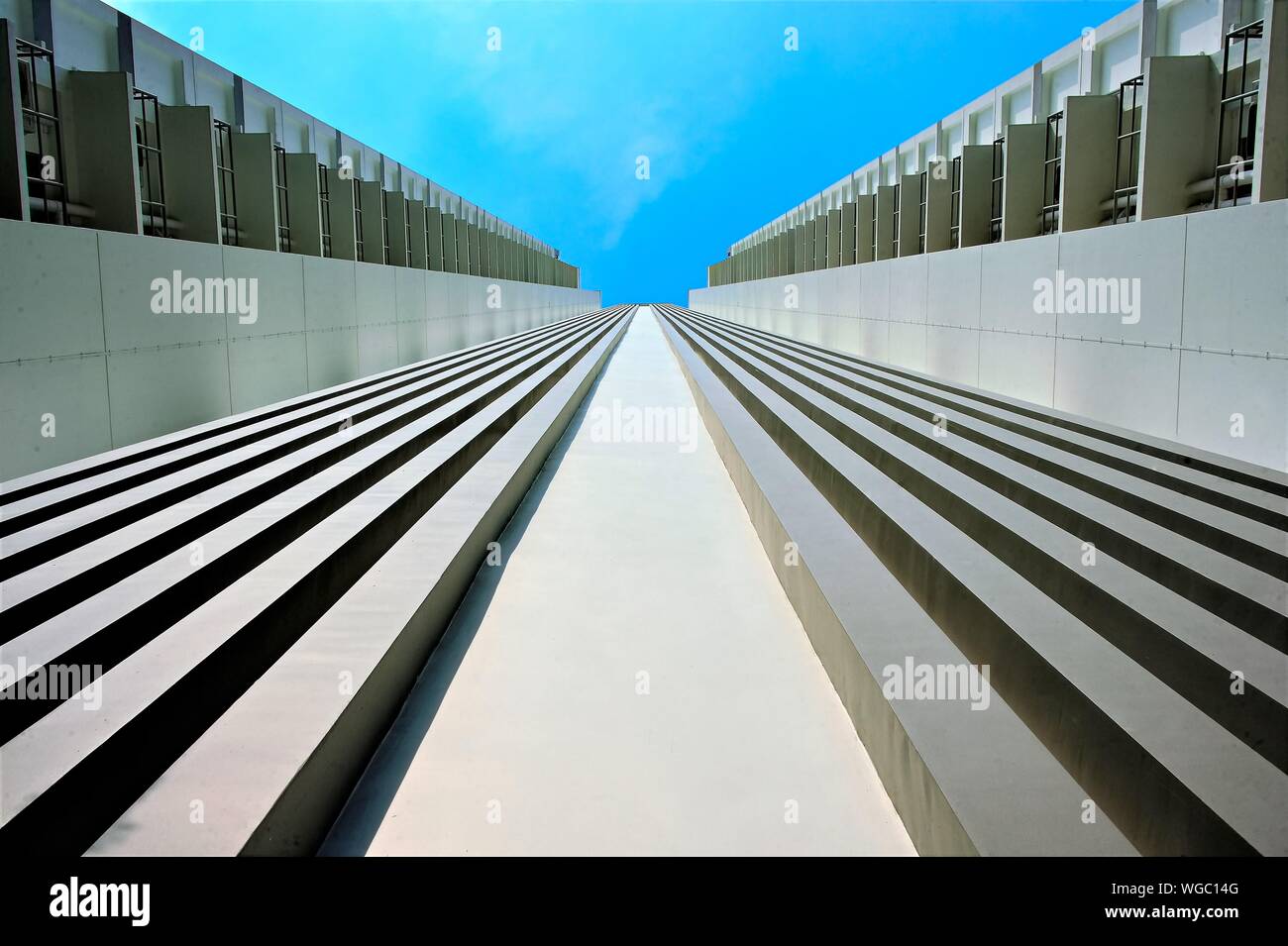 Vista prospettica fino esterno del moderno edificio di appartamenti a Singapore con forte delle linee guida e dettagli architettonici contro il cielo blu Foto Stock