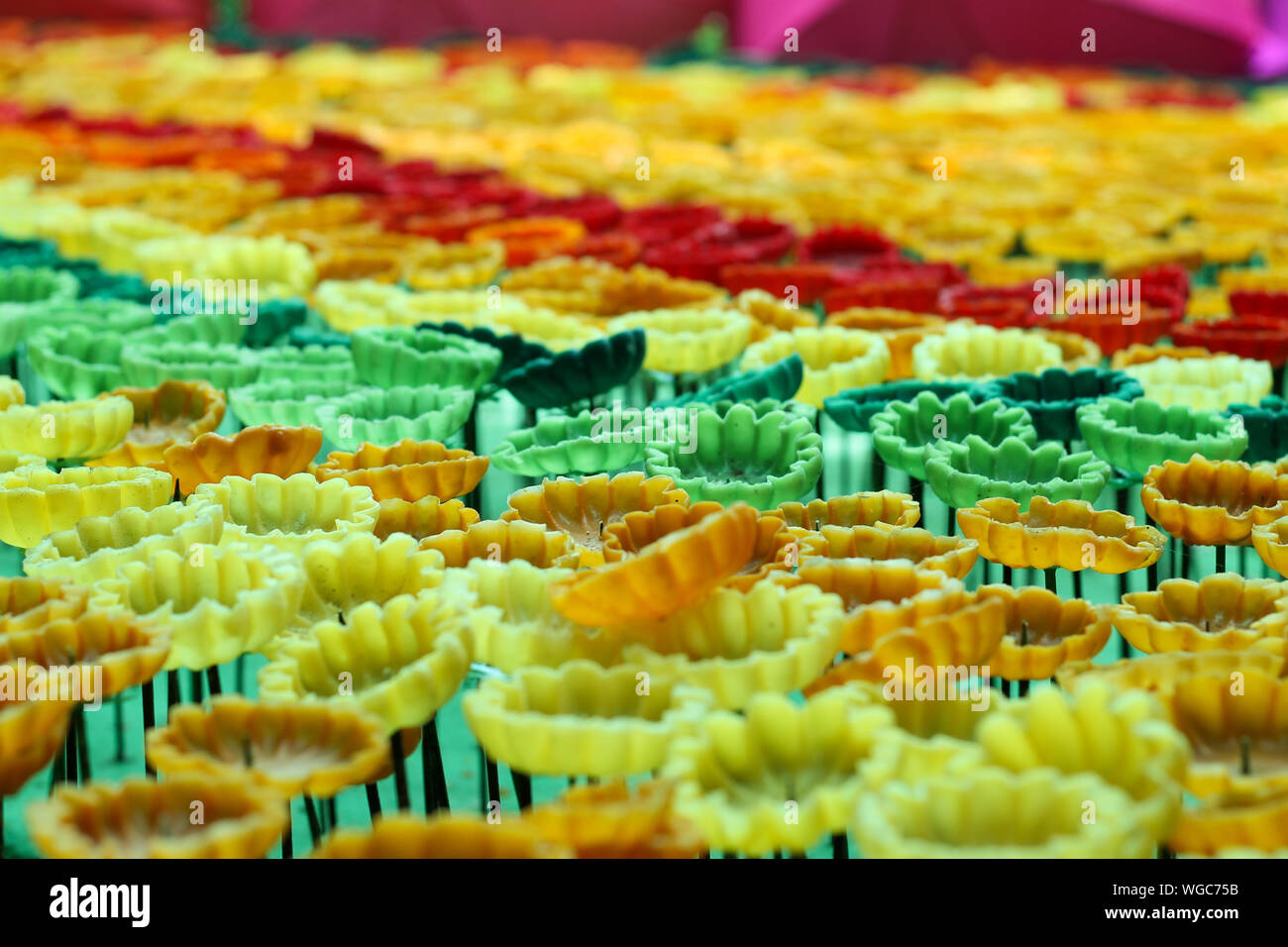 Fiori multicolori sono realizzati da candele come sfondo. Foto Stock