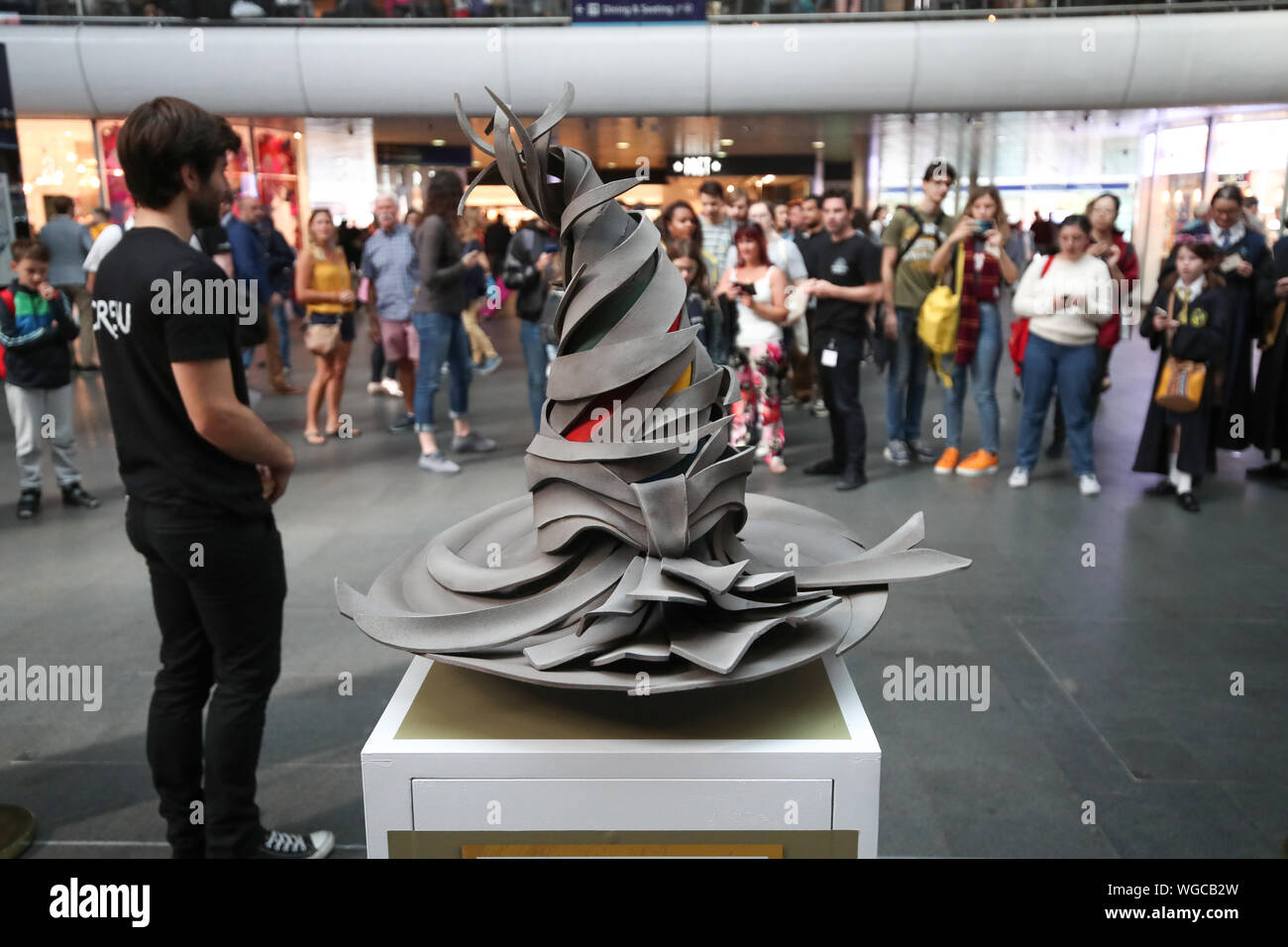 La cernita flottante Hat installazione che celebra il prossimo rilascio del nuovo mondo di Wizarding App a Londra Kings Cross Station come fan di Harry Potter si riuniscono per guardare come la scuola di Hogwarts Express viene visualizzato sulla scheda di partenza a Londra King's Cross durante la Torna a Hogwarts giorno. Foto Stock