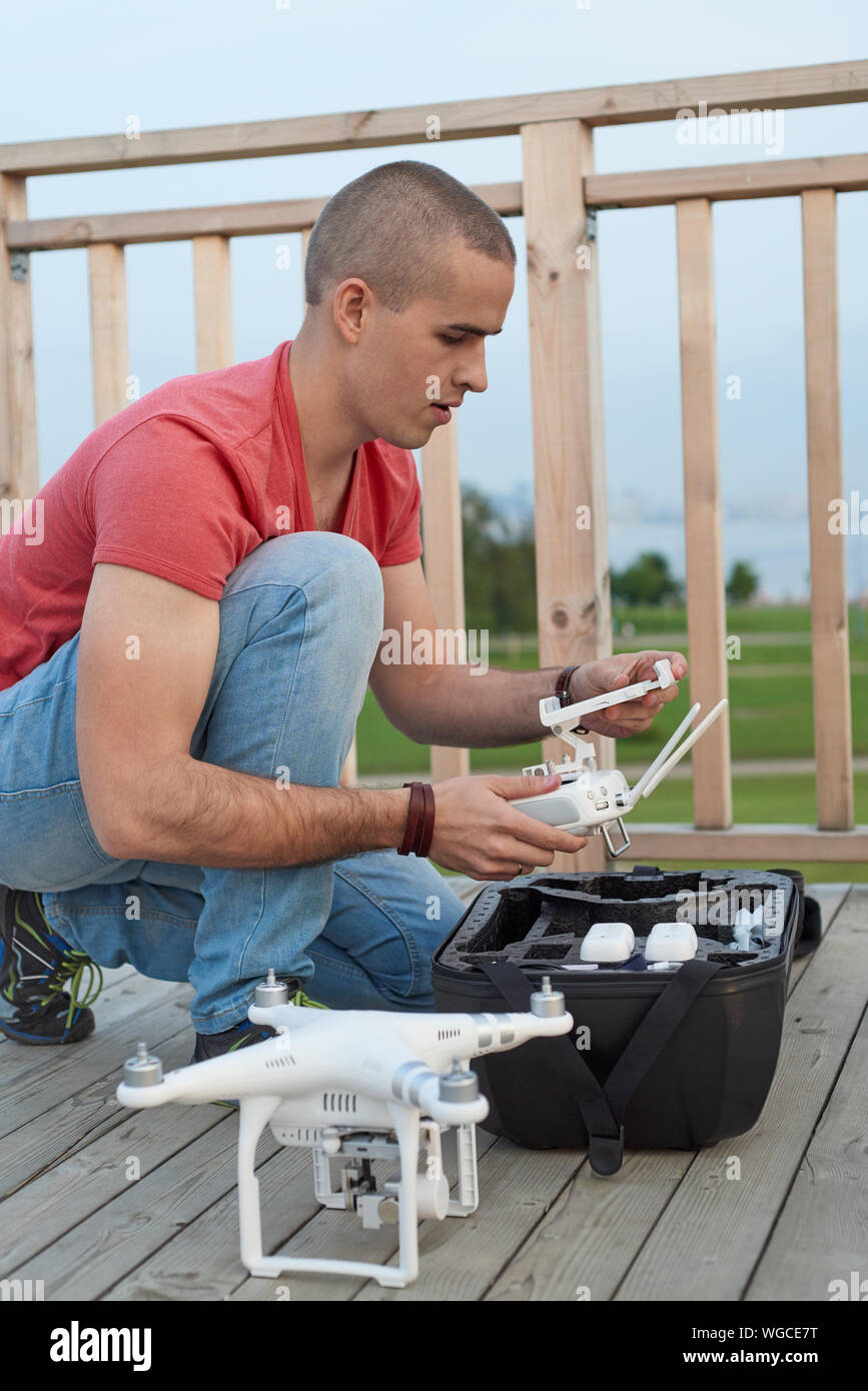 Giovane uomo impostazione drone nel parco. Immagine ravvicinata Foto Stock