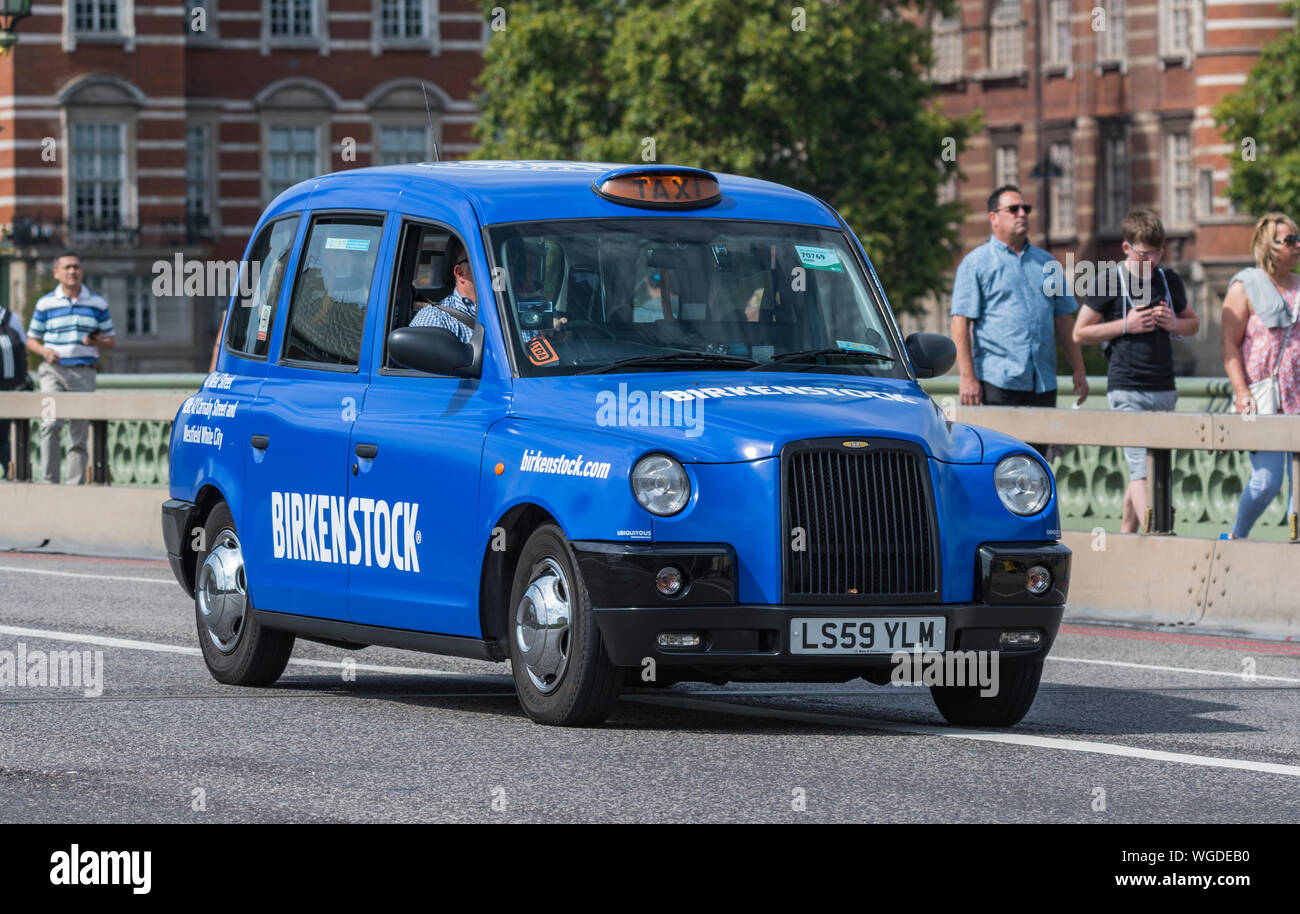 Blue LTI TX4 taxi con la pubblicità nella città di Westminster a Londra, Inghilterra, Regno Unito. Blu taxi a Londra. Blu cabina di Londra. Foto Stock