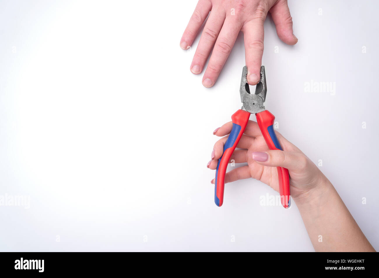 La moda donna di mano con una delicata manicure detiene un attrezzo. Di sicuro il lavoro, posto per un'iscrizione. Vista da sopra. Sfondo bianco, ombra contrastanti. Foto Stock