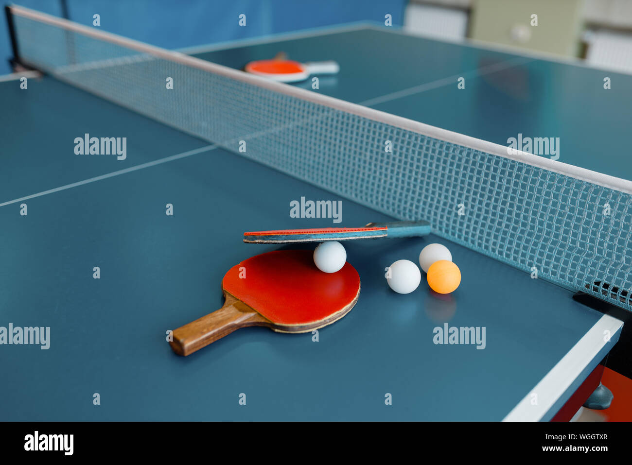 Ping pong racchette e palle sul tavolo da gioco con net Foto Stock