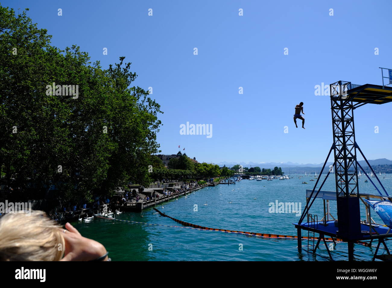Uomo di saltare fuori dieci metri di alta piattaforma nel lago di Zurigo Foto Stock