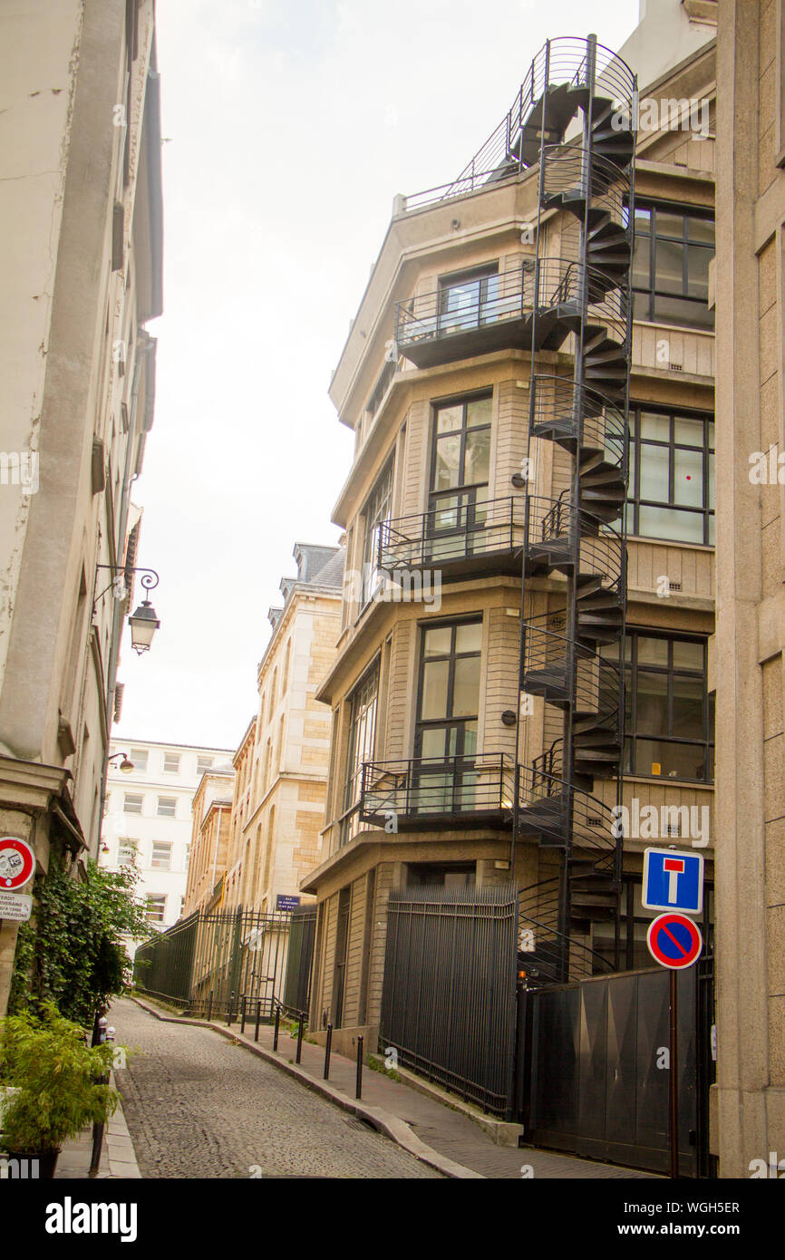 Parigi, Francia - luglio 7, 2018: stretta strada di Parigi e un edificio con una scala a spirale Foto Stock