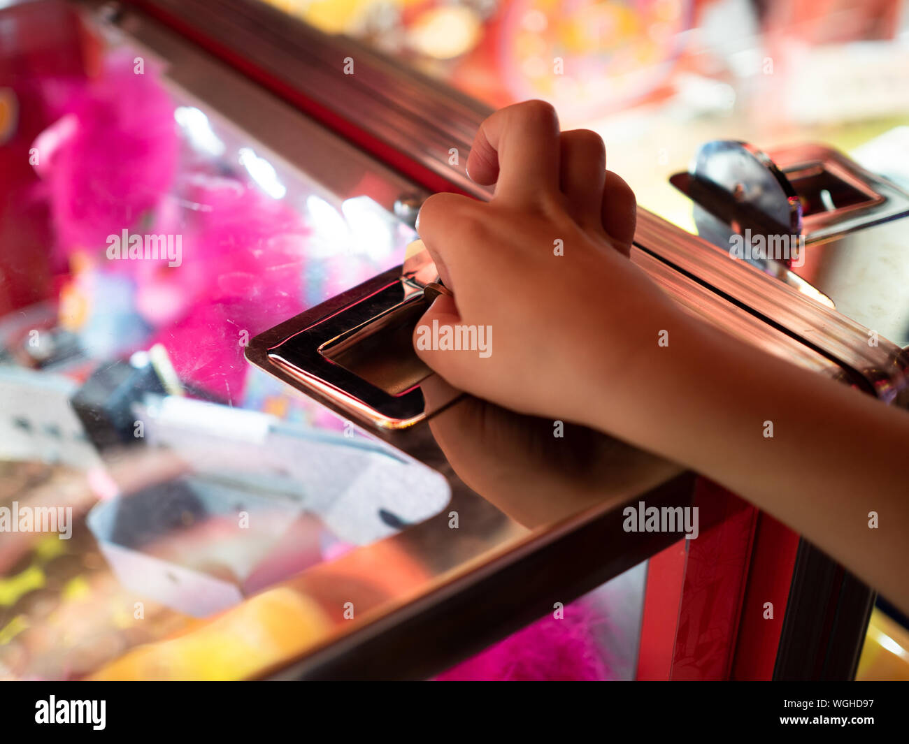 Un bambino di 5 anni ragazzo del braccio e della mano è illustrato l'inserimento di una moneta in un 2p slot machine su un britannico vacanza costiera. Foto Stock