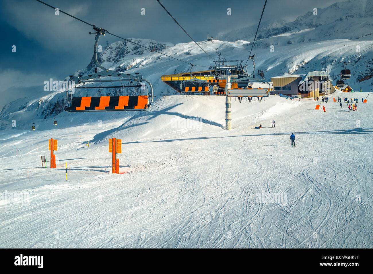 Rinomata stazione sciistica con piste innevate e felice di sciatori. Colorato fast funivie comming in su ed in giù con gli sciatori, Alpe d Huez, Francia, Europa Foto Stock