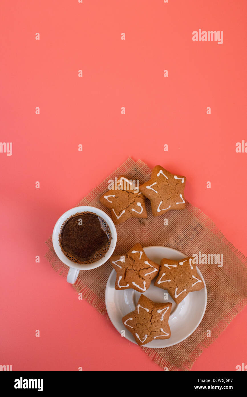 White Tazza da caffè con piattino su sfondo rosa con pan di zenzero. Foto Stock