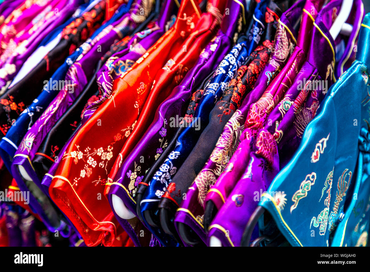 Cinese tradizionale qipao abiti appesi su una rotaia in China Town, Londra, Regno Unito Foto Stock