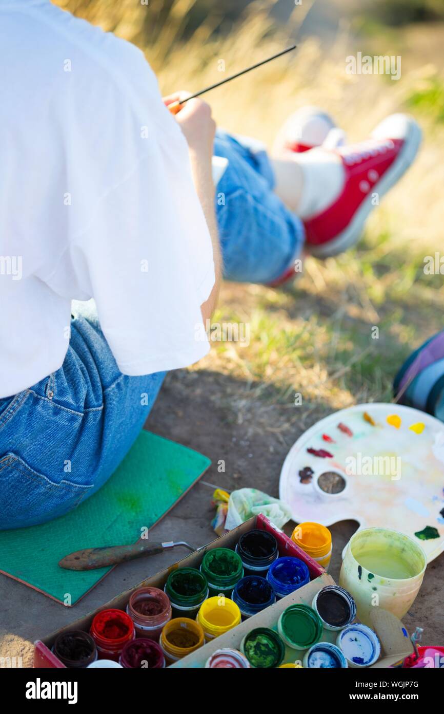 Tempo della creatività. La pittura en plein air. ragazza richiama un paesaggio in natura Foto Stock