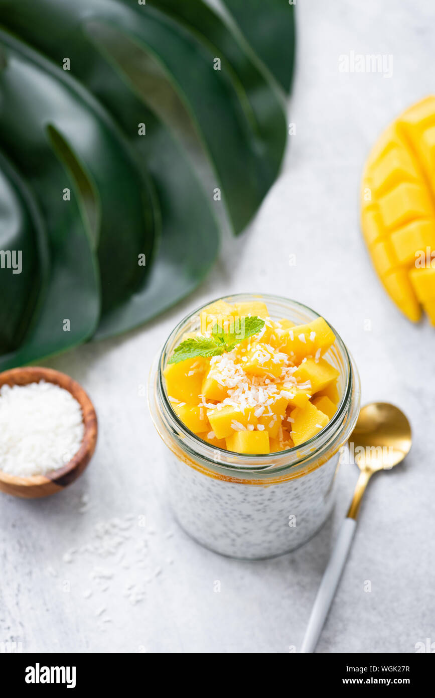 Yogurt di mango semi di Chia Pudding con scaglie di noce di cocco. Cibo sano e pulito il concetto di mangiare Foto Stock