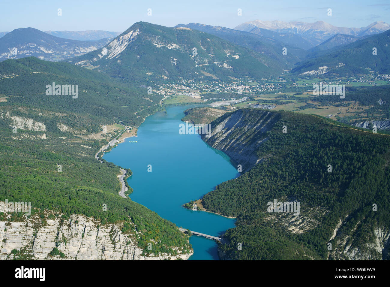 VISTA AEREA. Parte superiore del lago Castillon con la città di Saint-André alla fine del lago. Alpes de Haute-Provence, Francia. Foto Stock