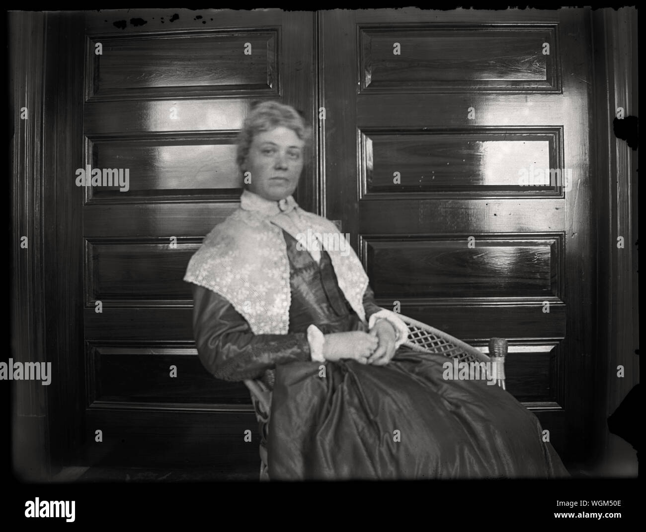 Ritratto di donna nella sedia di vimini indossando storico stile coloniale abito. Inizio periodo edoardiano fotografia amatoriale, scandita dall'originale 3x4 pollici lastra di vetro negativo circa primi 1900s. Foto Stock