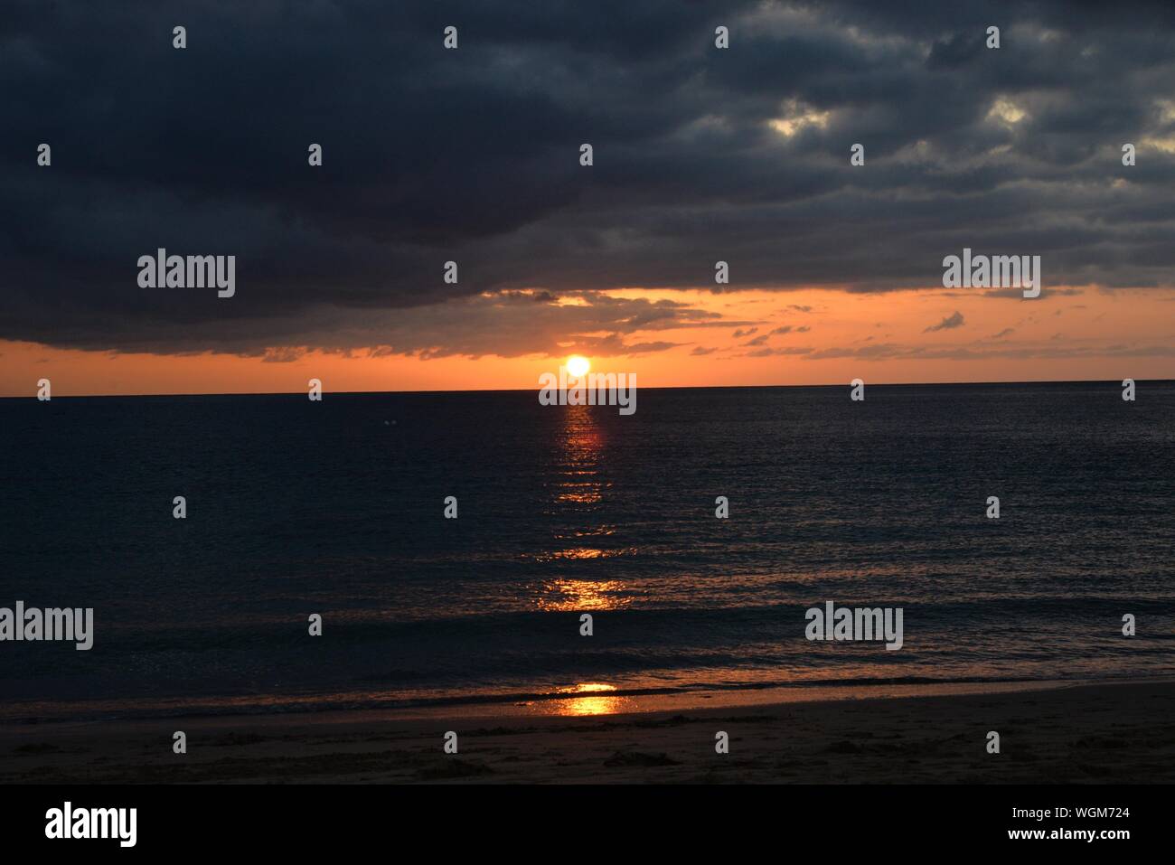 Vista panoramica del mare contro il cielo drammatico durante il tramonto Foto Stock