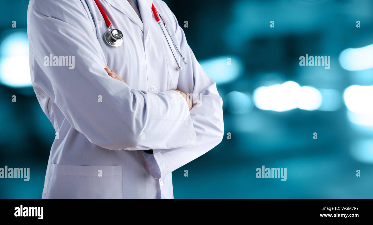 Medico uomo in camice bianco con uno stetoscopio su un abstract di sfocatura dello sfondo bokeh di fondo Foto Stock