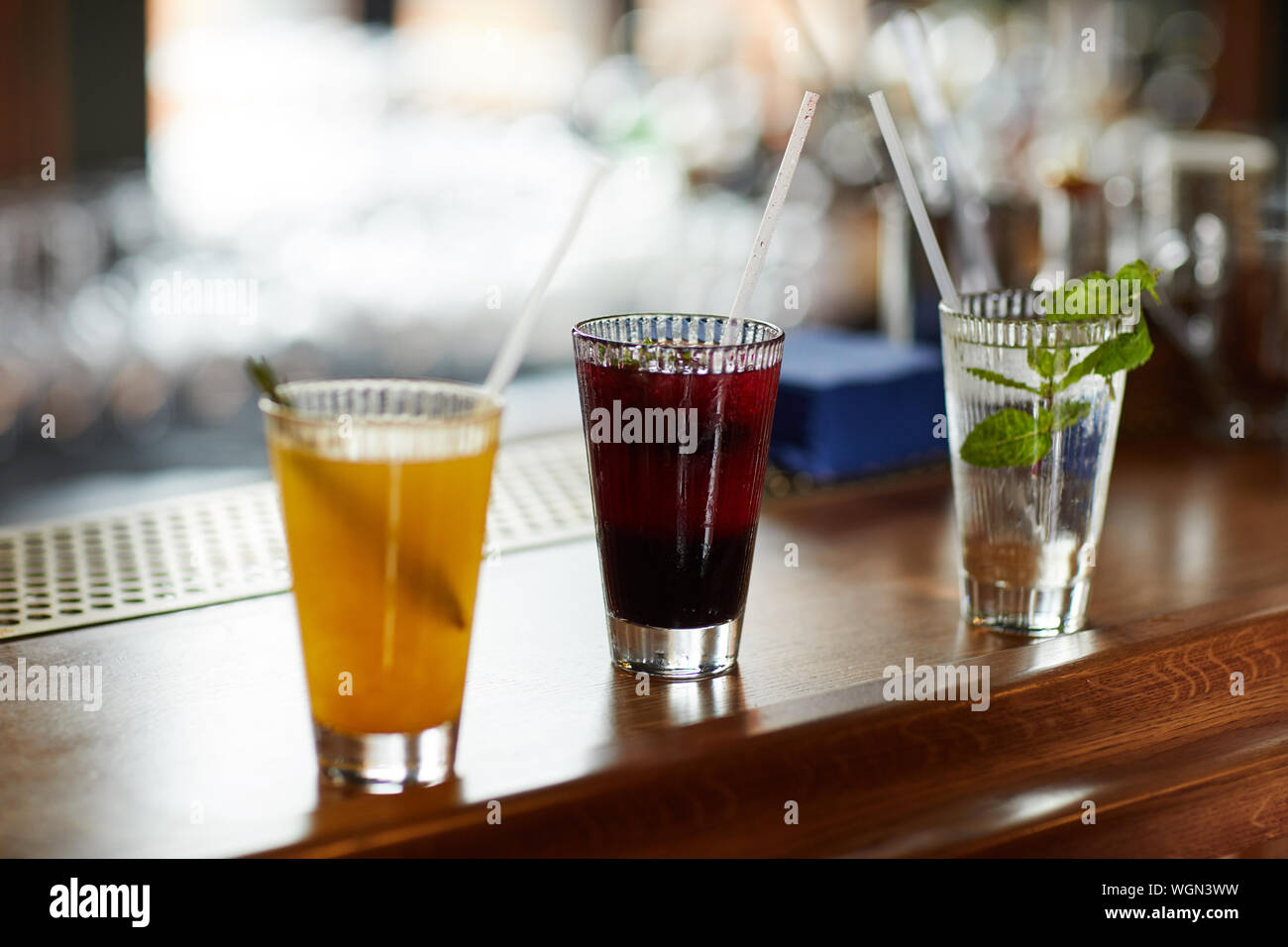 Fila di tre bevande colorate sul banco bar, cocktail rinfrescanti e mojito vetro, spazio di copia Foto Stock