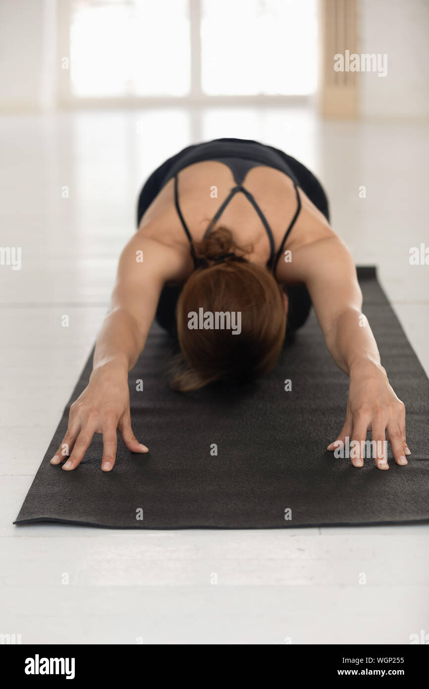 Donna pratica lo yoga, bambino pongono, Balasana esercizio, foto verticale Foto Stock