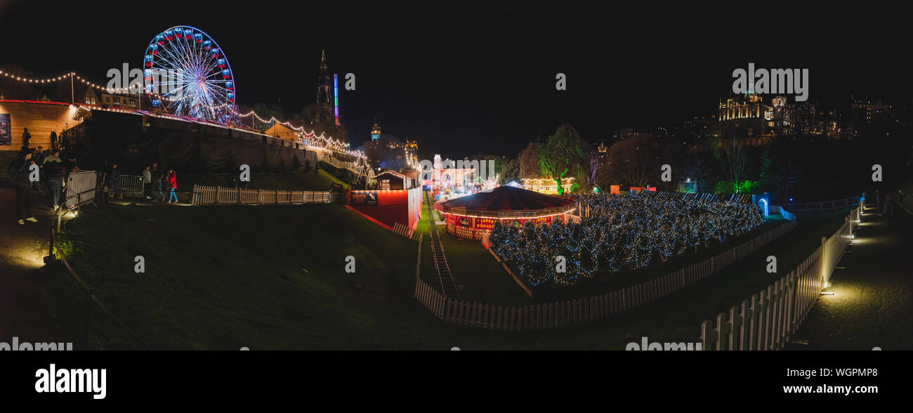 EDIMBURGO, SCOZIA 13 DICEMBRE 2018: Vista panoramica della fiera di Natale illuminata con un sacco di merchandising decorazione brillante e ruota della fortuna Foto Stock