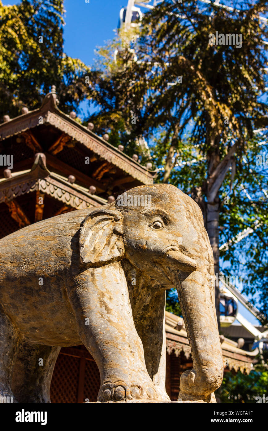 Un elefante in pietra statua fuori la parte anteriore di un tempio. Foto Stock