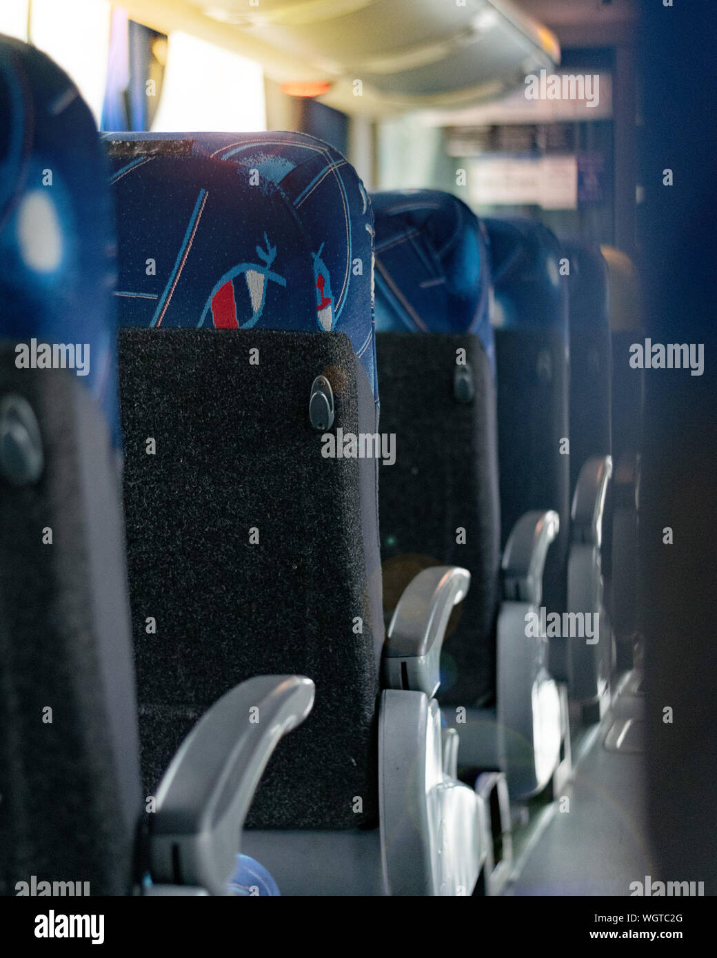 Sedili blu all'interno di un bus di viaggio interiore, corridoio vista e allineato Foto Stock