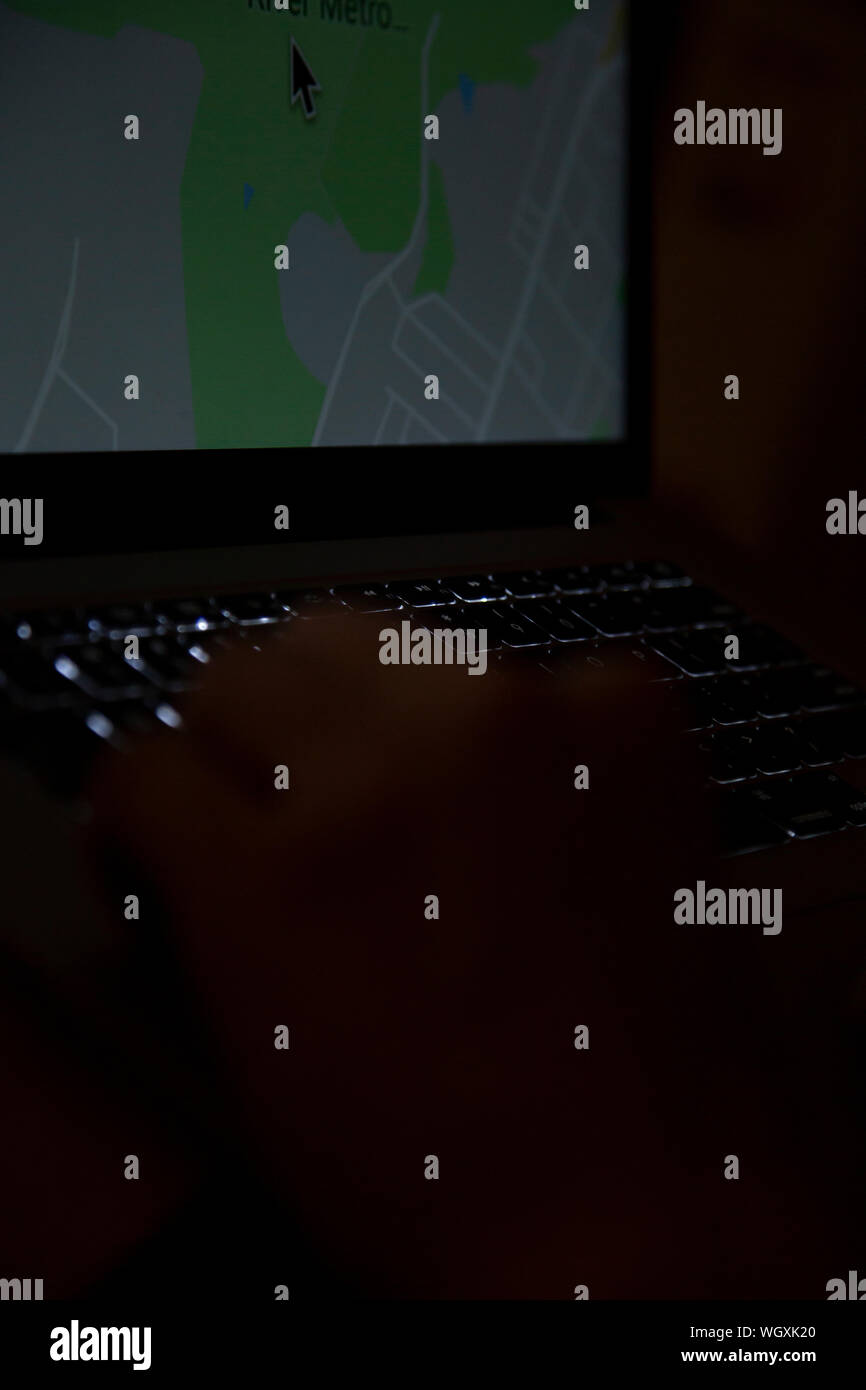 La mano della persona che utilizza un computer portatile aperto Foto Stock