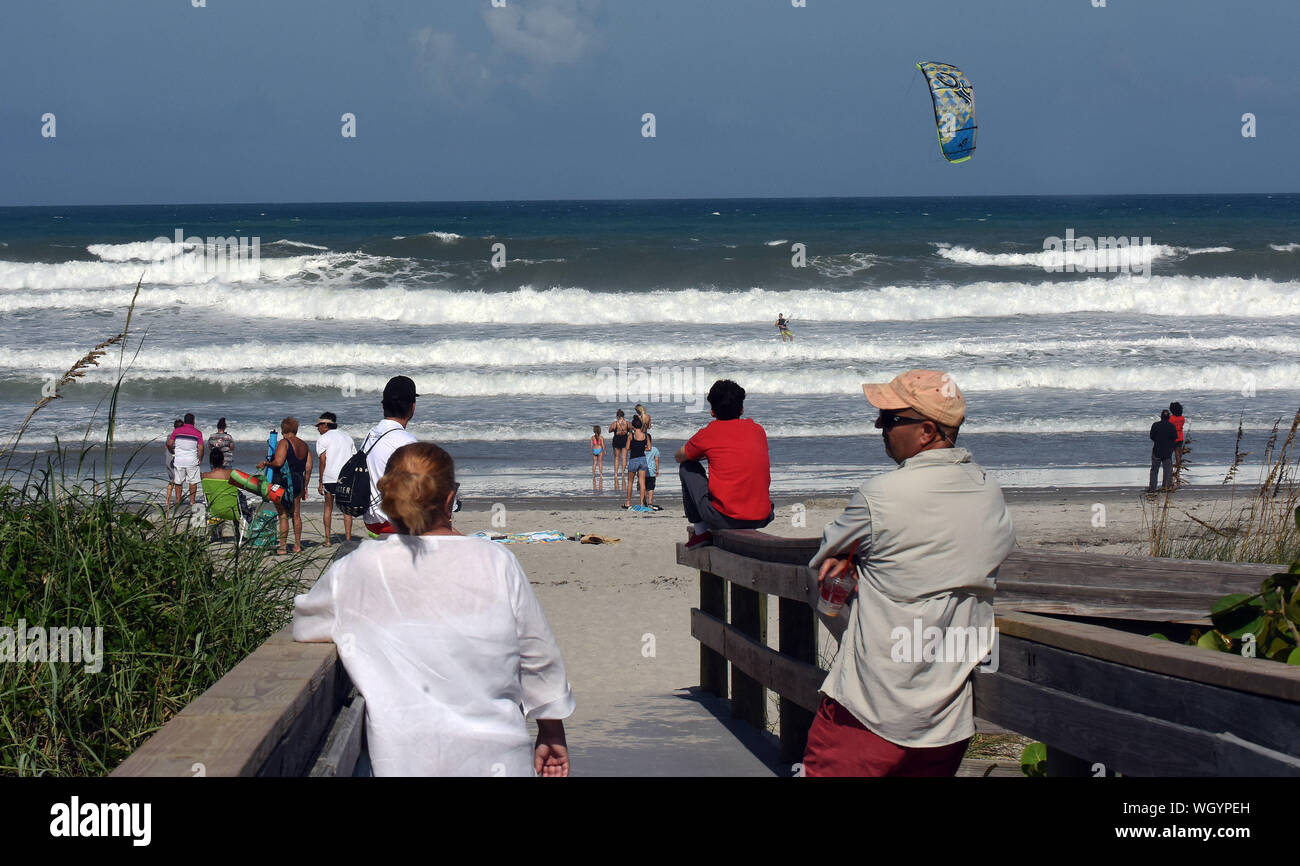 Indialantic Beach, Stati Uniti. 01 Sep, 2019. Spiaggia-frequentatori guardare come un uomo kiteboards nel pesante surf generato dall uragano Dorian. La categoria 5 storm è atteso a venire pericolosamente vicino alle coste della Florida come presto come domani notte. Credito: SOPA Immagini limitata/Alamy Live News Foto Stock