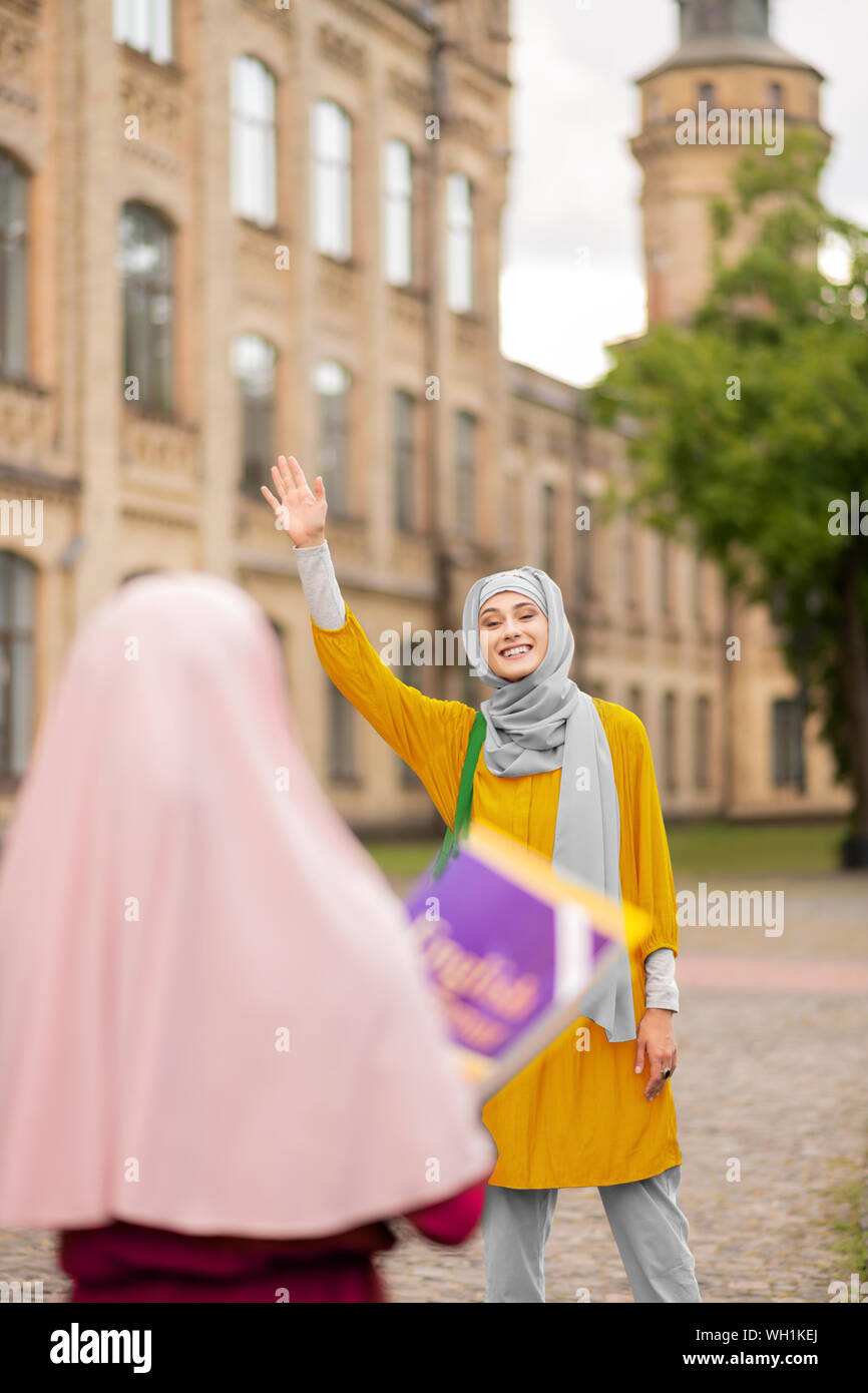 Studenti musulmani sventolando il suo amico mentre la riunione vicino Università Foto Stock